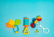 © phoenix021 - Baby rattles and chewing toy on blue background, copy space