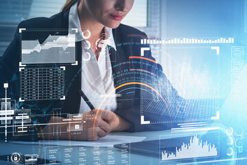 Poster - Businesswoman wearing suit is taking notes and looking at laptop