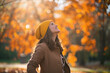 happy trendy woman in brown coat and yellow hat