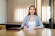 © JackF - Female lawyer sitting at desk and looking in camera while filling out information in document.