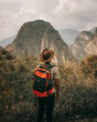 Explorator hikking with backpack in the jungle with a hat and montain views