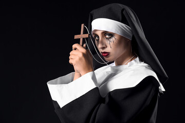 Woman dressed for Halloween as nun on dark background