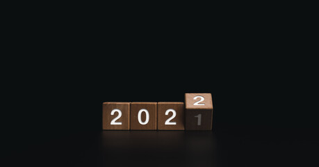 Poster - 2022 Happy New year welcome and Merry Christmas banner. Flipping wooden cube blocks for changing the year from 2021 to 2022 on dark background.