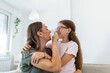 © Graphicroyalty - Close up of sweet pretty daughter cuddling with her young mother. Lovely mother embracing her cute daughter on the sofa at home.