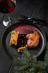 Wall Mural - Roasted duck leg confit with cranberry sauce on wooden table.