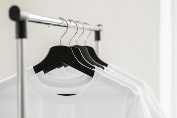 Poster - Row of white t-shirts on hangers on rack