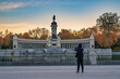 © Noppasinw - Madrid Spain, sunrise city skyline at El Retiro Park with woman tourist and autumn foliage season