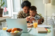 © Yakobchuk Olena - Lovely multiracial soldier woman eating cupcakes with her son during the breakfast
