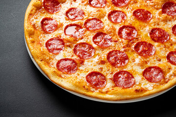 Canvas Print - Tasty pepperoni and tomatoes on black background