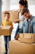 © NDABCREATIVITY - Happy family unpacking boxes in new home on moving day