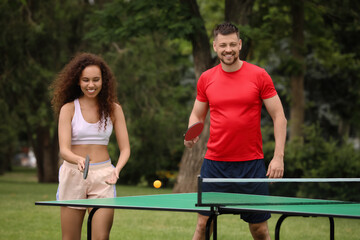 Wall Mural - Friends playing ping pong outdoors on summer day