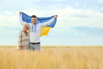 Poster - Man with mother holding national flag of Ukraine in field. Space for text