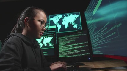 Asian Young Girl Hacker Hacking With Multiple Computer Screens In Dark Room
