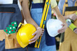 © megaflopp - Group of construction workers are holding protective helmets with tools and toy christmas tree closeup