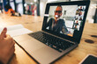 © Jacob Lund - Anonymous businesswoman attending a virtual meeting in a modern office