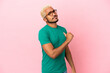 Young Colombian handsome man isolated on pink background proud and self-satisfied