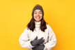 © luismolinero - Young woman with winter hat over isolated yellow background smiling a lot