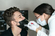 the doctor takes a swab from the young man's nose, DNA test, PCR test. Selective focus