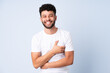 © luismolinero - Young Moroccan man isolated on blue background smiling a lot