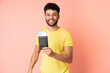 © luismolinero - Young Moroccan man isolated on pink background in vacation with suitcase and passport