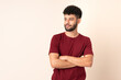 © luismolinero - Young Moroccan man isolated on beige background looking to the side