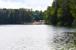 Jezioro Srebrne w Osowcu latem. Widok na jezioro, las i plażę z turystami