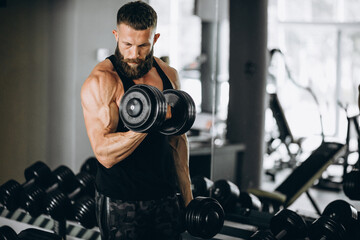 Handsome man bodybuilder doing workout at gym