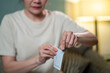 © CandyRetriever  - Asian woman using rapid antigen test kit for self test COVID-19 epidemic at home. Adult female unpacking COVID-19 antigen test kit from package. COVID-19 coronavirus pandemic protection concept.