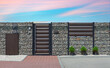 Modern wicket integrated with gabions wall. Fence made of gabions. Closed metal gate to property, part of modern stone wall fence with mailbox at street
