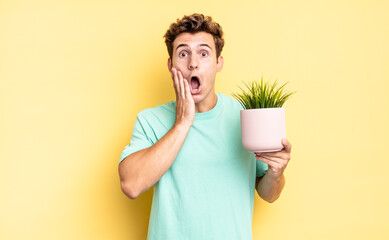 Wall Mural - feeling shocked and scared, looking terrified with open mouth and hands on cheeks. decorative plant concept