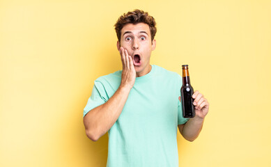 Wall Mural - feeling shocked and scared, looking terrified with open mouth and hands on cheeks. beer bottle concept