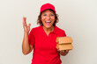 © Asier - Middle age delivery woman taking burguers isolated on white background receiving a pleasant surprise, excited and raising hands.