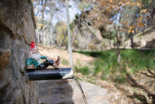 Gnome Lying On A Water Spout From A Fountain Found In A Forest With Autumn Colors In Sierra De Huetor