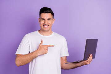 Photo of young man happy positive smile point finger laptop advice choice ad isolated over purple color background