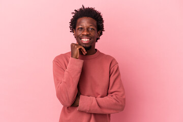 Wall Mural - Young african american man isolated on pink background smiling happy and confident, touching chin with hand.