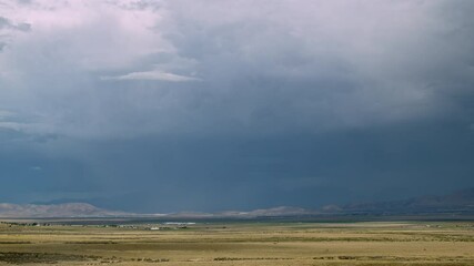 Wall Mural - Time-lapse of clouds at the end of a storm moving and sun shining lighting up the valley in Utah.