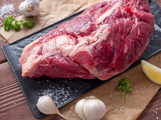 Canvas Print - a piece of marbled beef lies on parchment surrounded by herbs, garlic, salt. Top view, flat lay. food composition