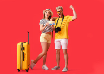 Couple of tourists with gift voucher on color background