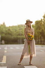 Wall Mural - Portrait of beautiful woman with sunflowers outdoor at summer