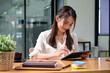 © Prathankarnpap - Smiling businesswoman using digital tablet at office.