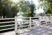 Beautiful White Wooden Pedestrian Bridge Over The River In A Summer Picturesque Park.