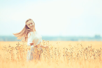 Wall Mural - blonde with long hair in autumn field / concept of happiness health young adult model in summer landscape