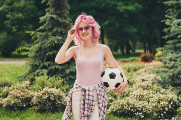 Photo of young sportive girl happy positive smile hold soccer ball player game park nature hand touch sunglass outdoors