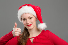 Young Woman With Santa Claus Hat Shows Thumbs Up