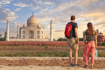 Fototapete - Tourist couple enjoy Taj Mahal monument at sunset from Mehtab Bagh at Agra, India