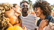 © Davide Angelini - Young happy people laughing together - Multiracial friends group having fun on city street - Diverse culture students portrait celebrating outside - Friendship, community, youth, university concept.