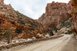 Gravel road of Swartberg pass winding through contorted rock formations