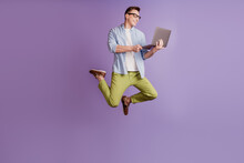 Portrait Of Programmer Guy Jump Hold Laptop Typing Working On Violet Background
