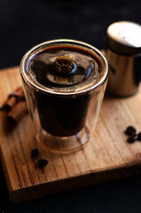 Canvas Print - Double espresso coffee mug with cinnamon sticks and coffee beans on a wooden board