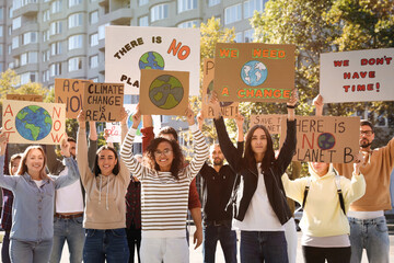 Group of people with posters protesting against climate change on city street